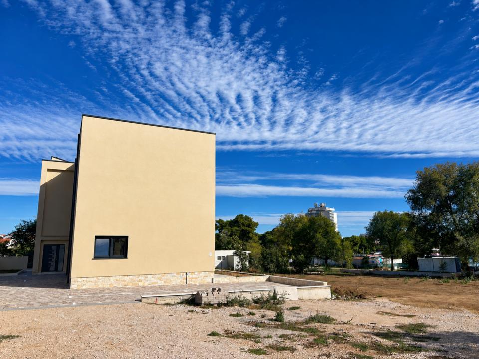 original_1792006884_modern-house-under-a-rippling-blue-sky.png