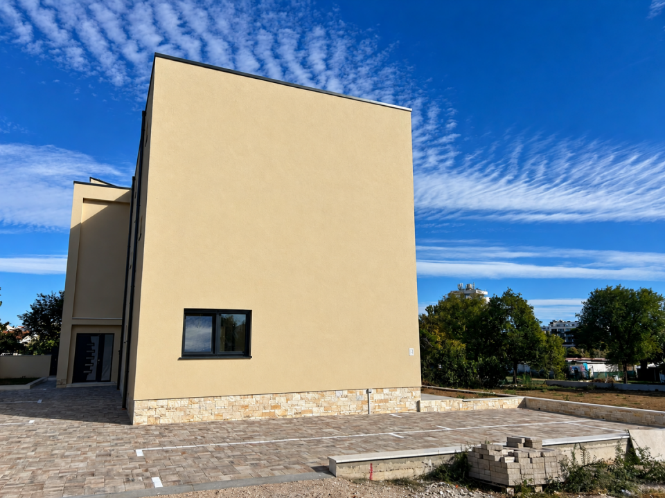 original_1792007183_modern-beige-stucco-building-under-streaked-skies.png